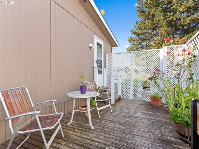 a balcony with table and chairs with wooden floor
