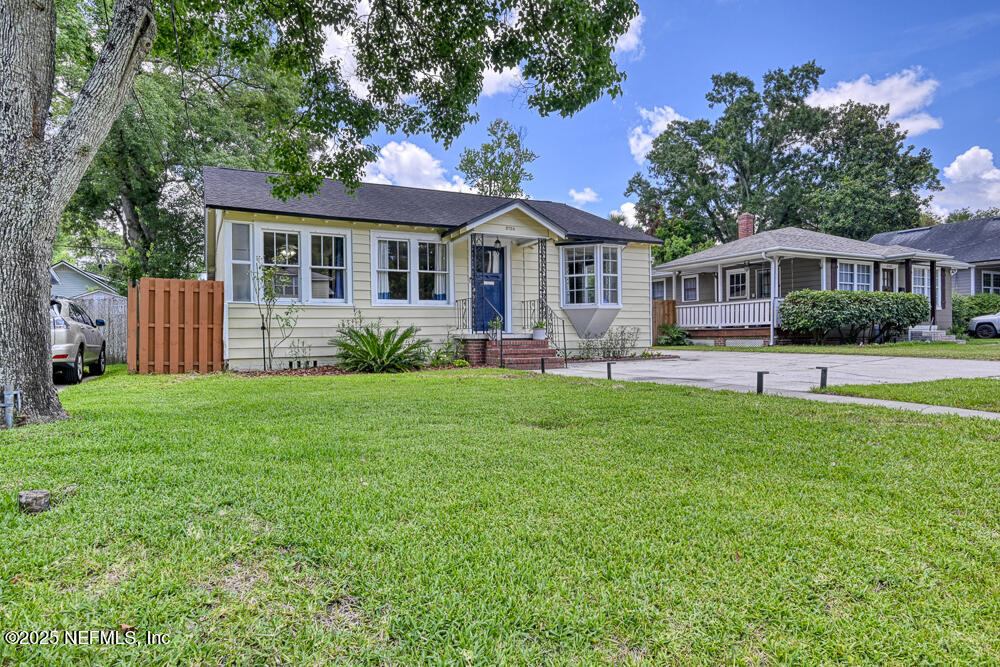a front view of a house with a yard and green space