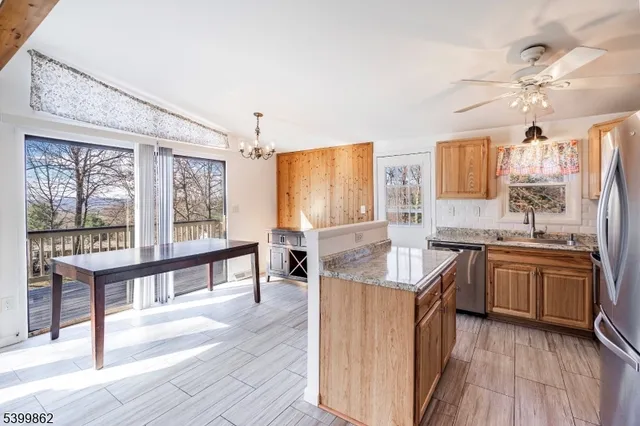 a kitchen with stainless steel appliances granite countertop hardwood floor sink stove and wooden cabinets