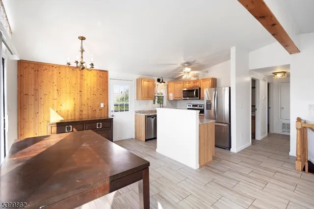 a kitchen with stainless steel appliances granite countertop a refrigerator a sink dishwasher and white cabinets with wooden floor