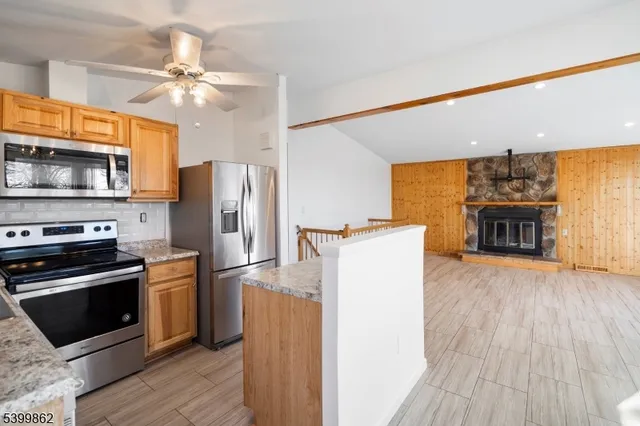 a kitchen with kitchen island a refrigerator stove and oven