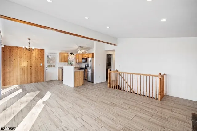 a view of a kitchen with refrigerator and wooden floor