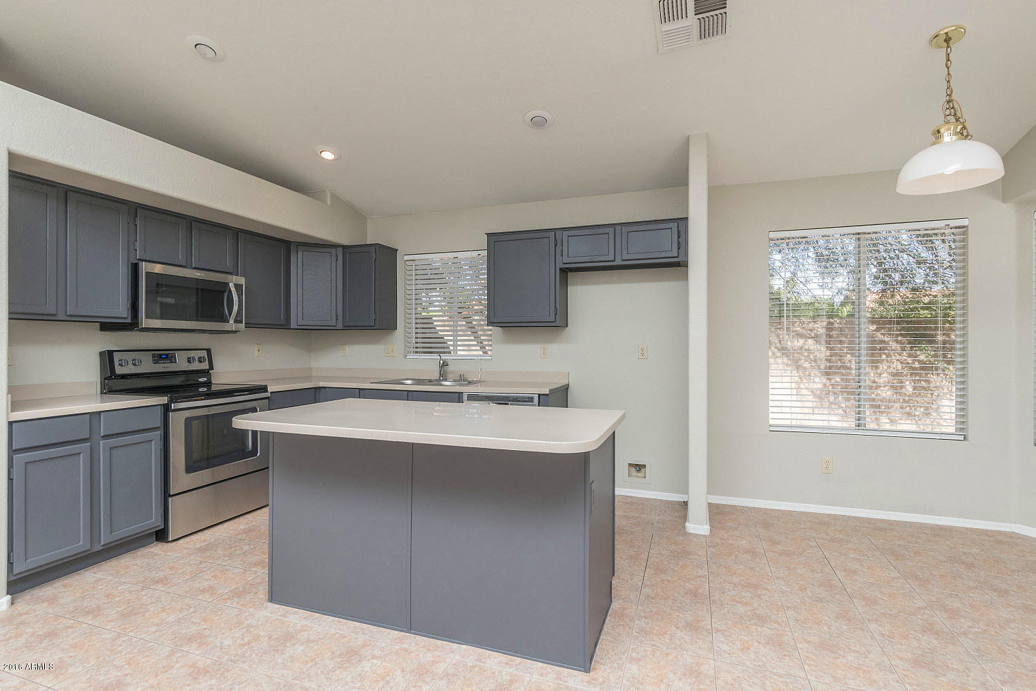 425 West Smoke Tree Road Gilbert, AZ 85233 - Photo 4 of 18 a kitchen with kitchen island a sink stainless steel appliances and cabinets