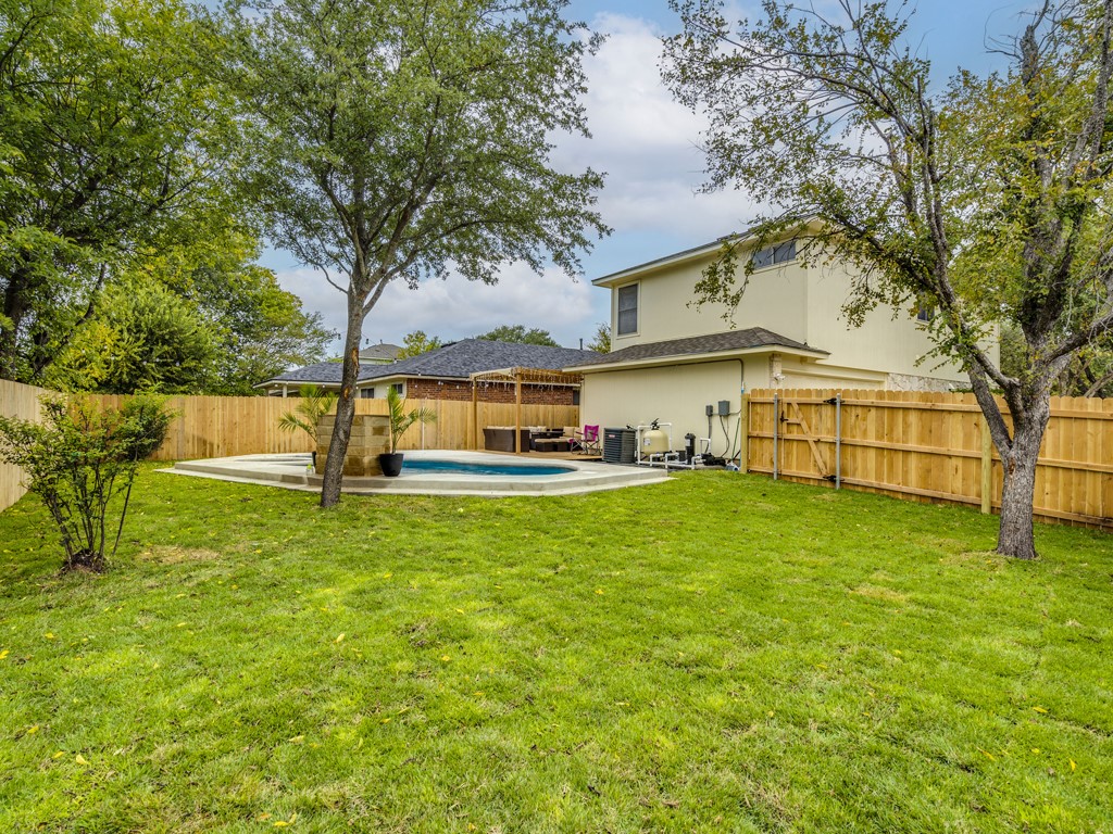 1415 Roxanne's Run Pflugerville, TX 78660 - Photo 29 of 30 A private outdoor haven features a glistening pool and lush, verdant lawn, all enclosed by sturdy fencing.