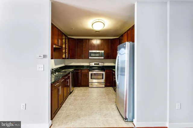 a kitchen with granite countertop stainless steel appliances and wooden cabinets