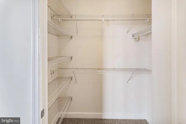 a view of a hallway with wooden floor and closet area