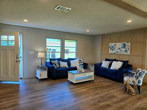 a living room with furniture and a wooden floor
