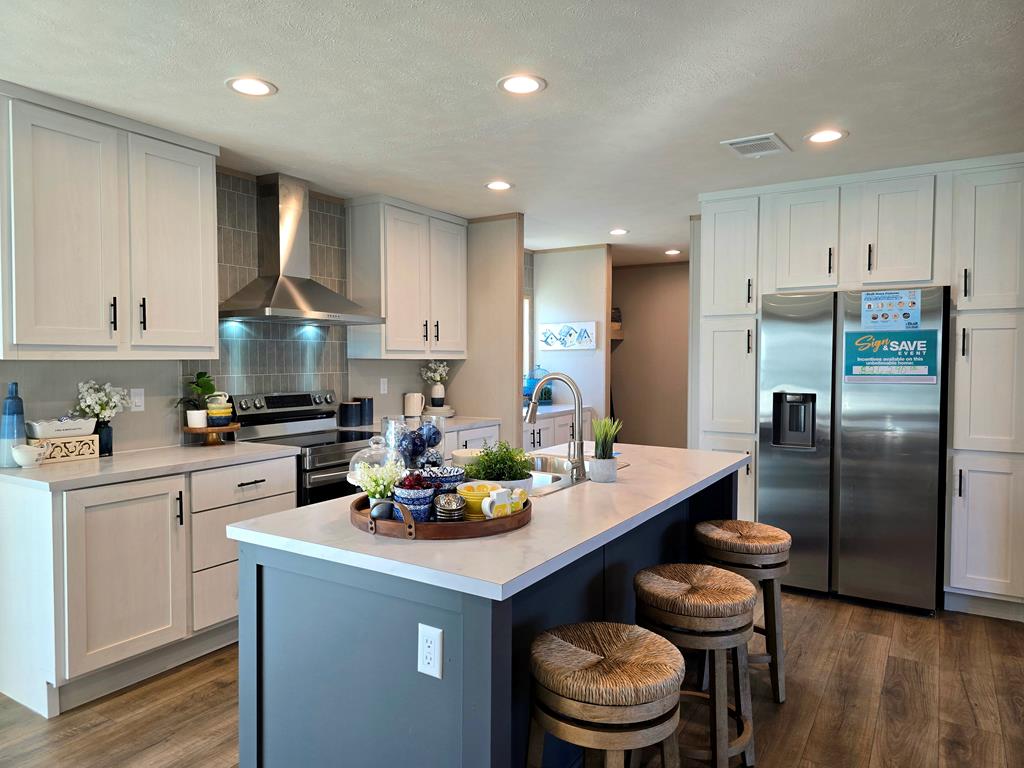 110 Deer Ridge Mason, TX 76856 - Photo 4 of 8 a kitchen with a refrigerator a stove a sink and a cabinets