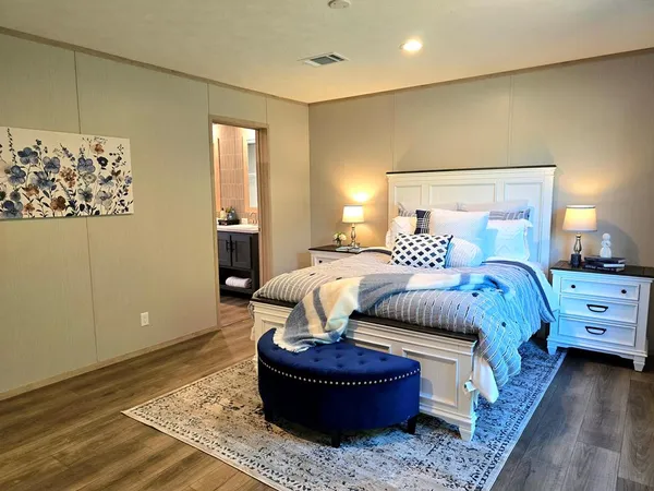 a bedroom with a bed and wooden floor