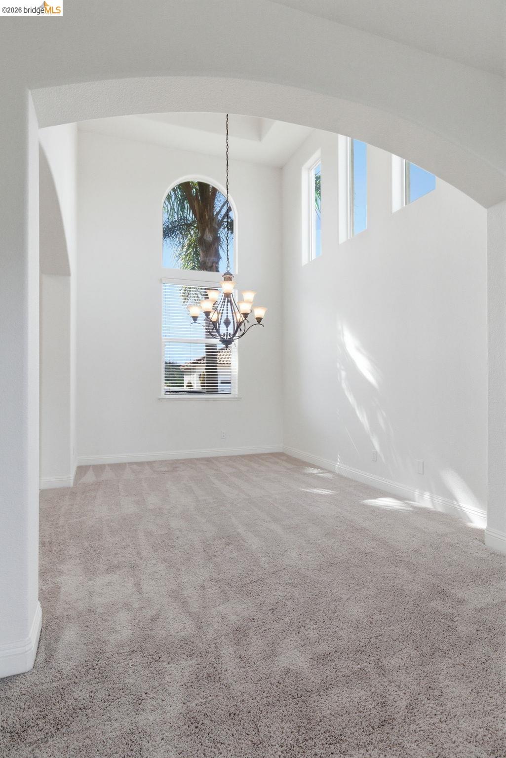 32 Apollo Lane Copperopolis, CA 95228 - Photo 14 of 58 Empty room featuring light colored carpet, plenty of natural light, and hanging lights