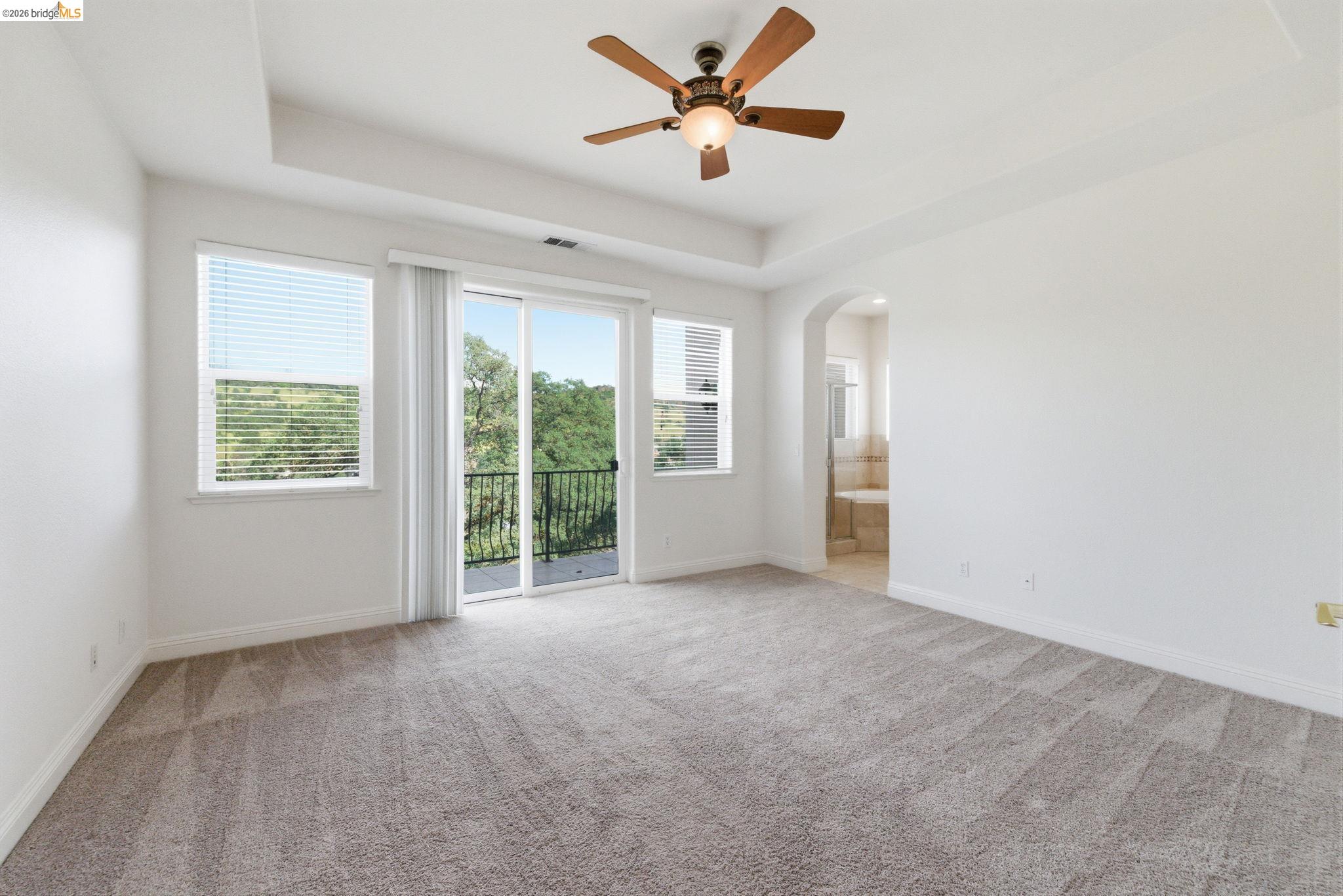 32 Apollo Lane Copperopolis, CA 95228 - Photo 25 of 58 Unfurnished room featuring a ceiling fan, a raised ceiling, arched walkways, and light colored carpet