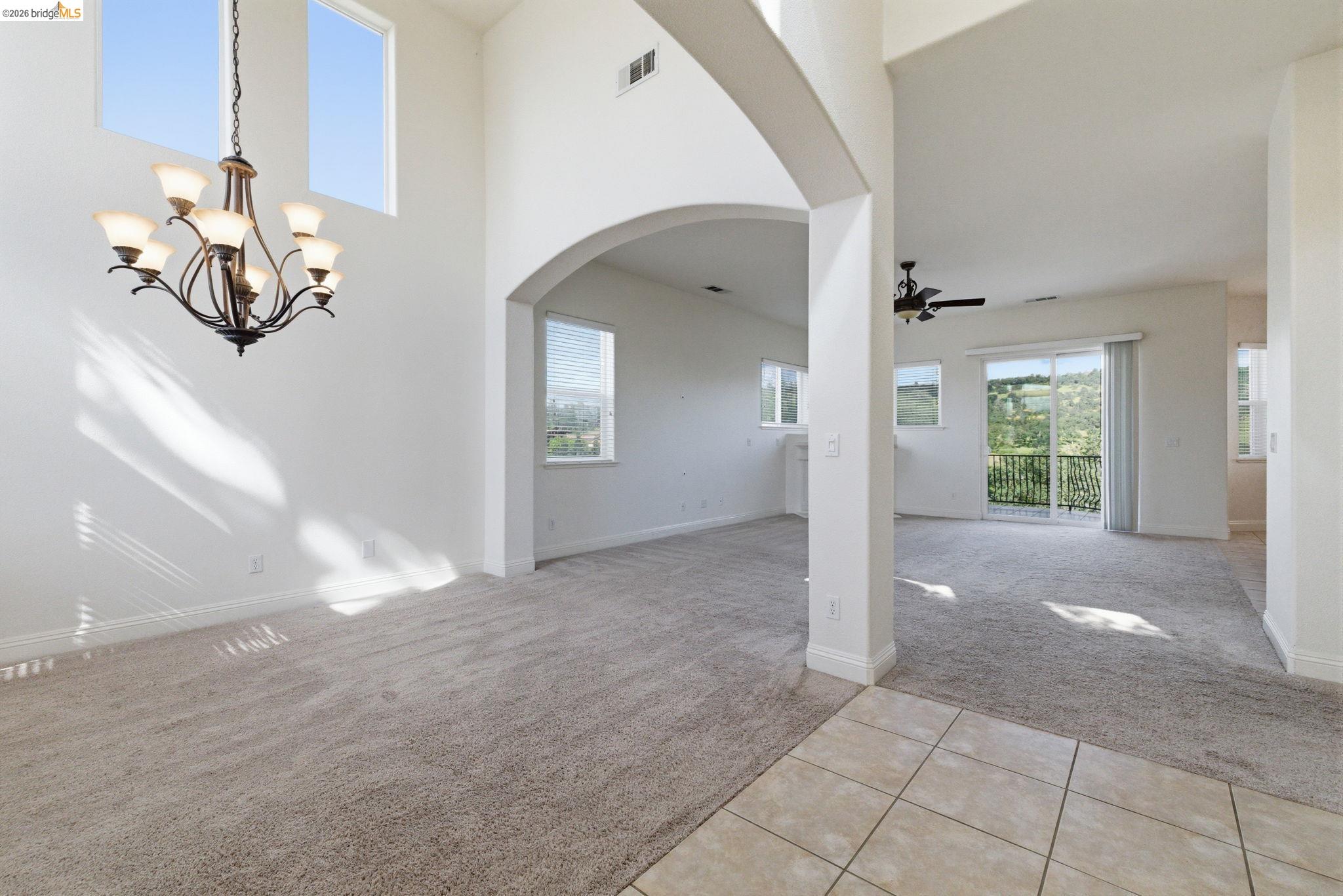 32 Apollo Lane Copperopolis, CA 95228 - Photo 4 of 58 Entrance foyer with light carpet, light tile patterned flooring, plenty of natural light, arched walkways, and a high ceiling