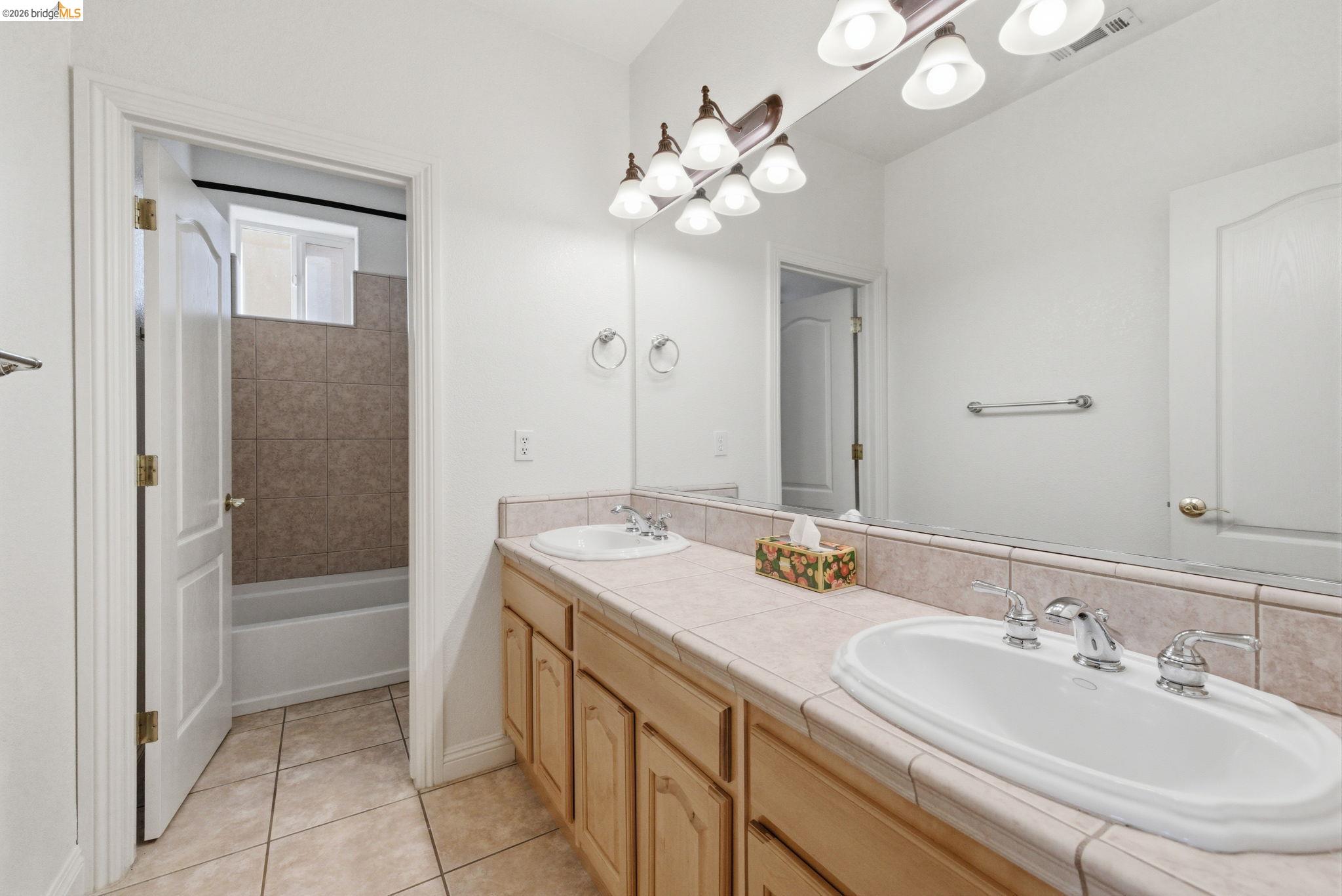32 Apollo Lane Copperopolis, CA 95228 - Photo 40 of 58 Bathroom with double vanity, light tile patterned floors, and bathing tub / shower combination