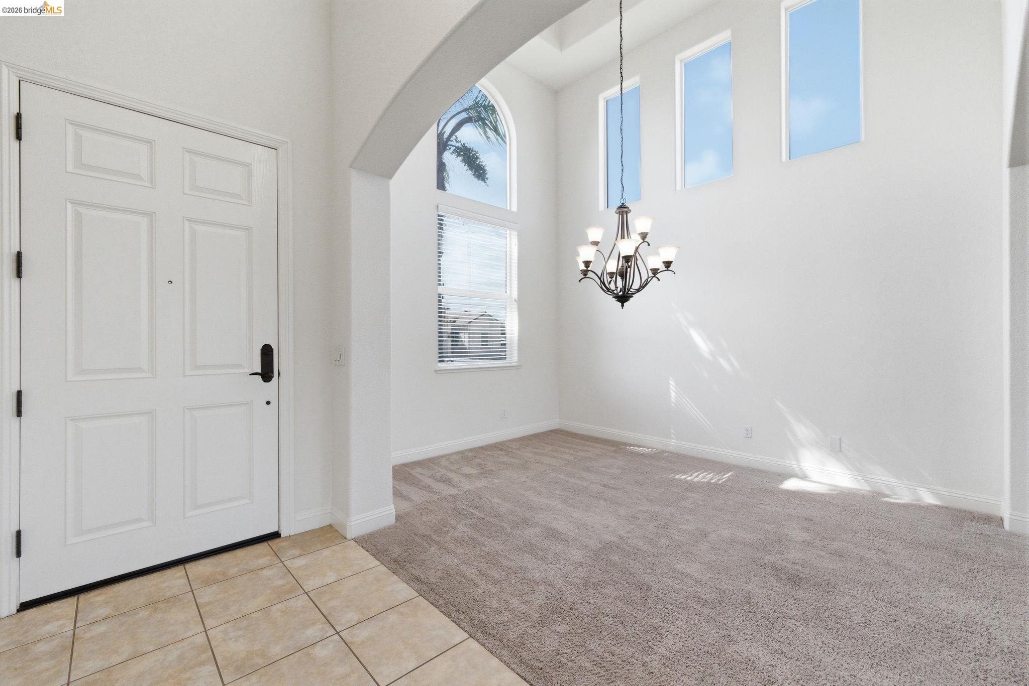 32 Apollo Lane Copperopolis, CA 95228 - Photo 5 of 58 Foyer entrance with light carpet, light tile patterned floors, a high ceiling, arched walkways, and suspended lighting