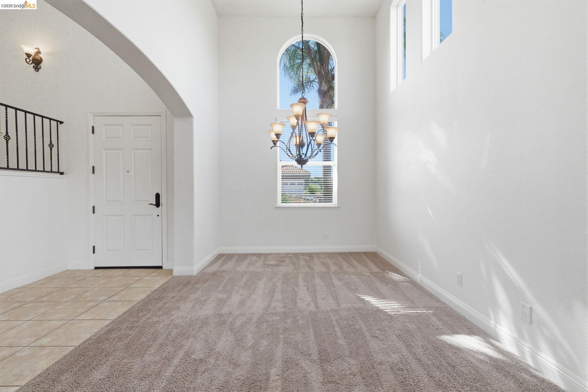32 Apollo Lane Copperopolis, CA 95228 - Photo 6 of 58 Foyer entrance featuring a high ceiling, arched walkways, suspended lighting, light tile patterned flooring, and light colored carpet