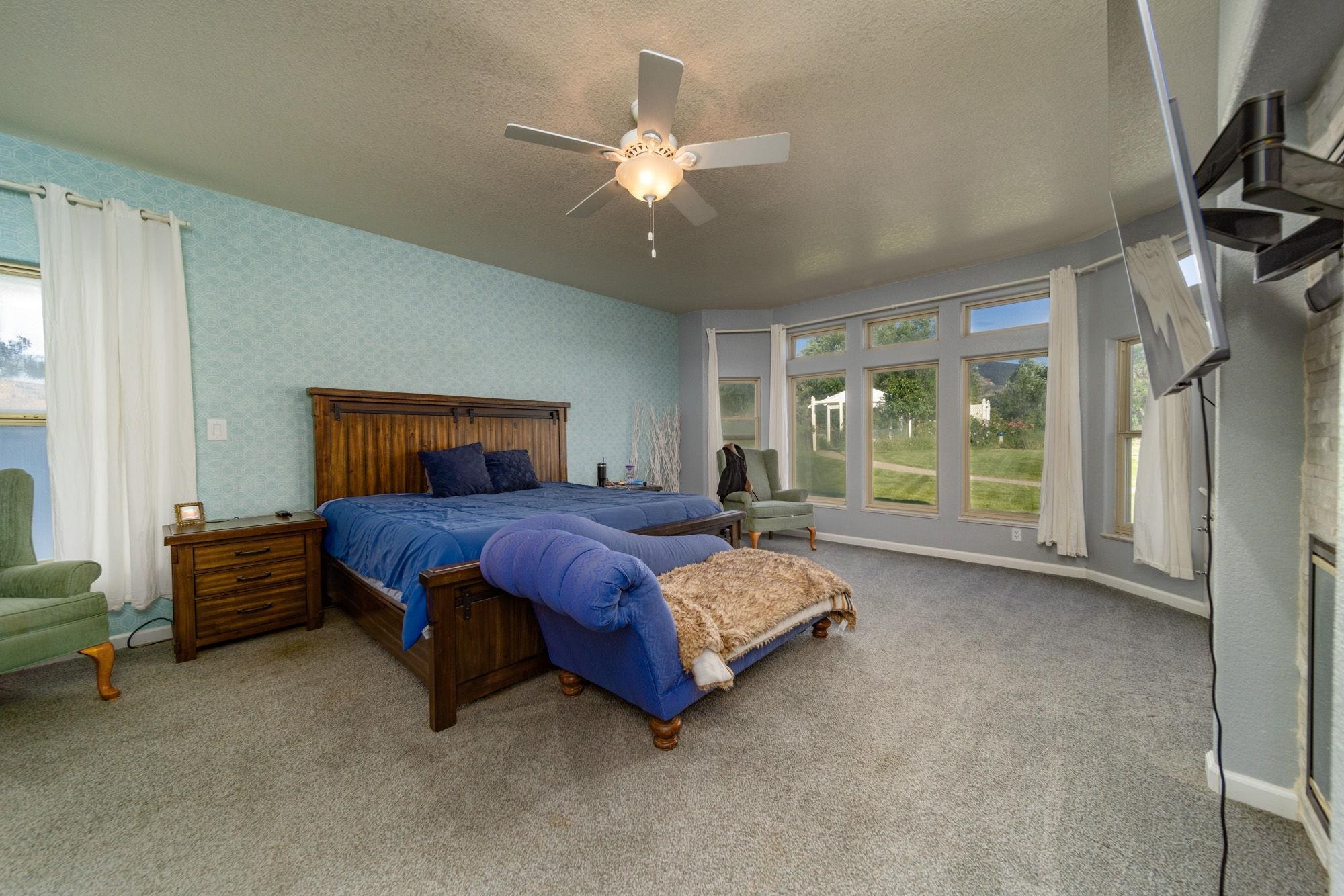 623 Sobre El Rio Drive Palisade, CO 81526 - Photo 14 of 28 a spacious bedroom with a bed and a chandelier