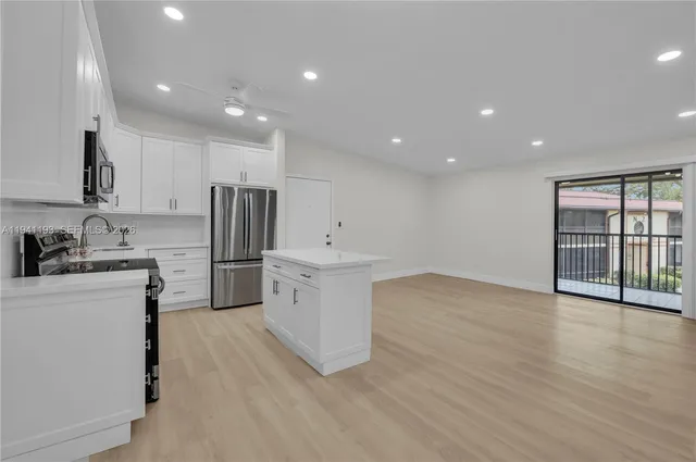 a kitchen with stainless steel appliances a refrigerator sink and cabinets