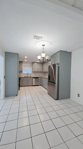 a kitchen with stainless steel appliances kitchen island a refrigerator sink and cabinets