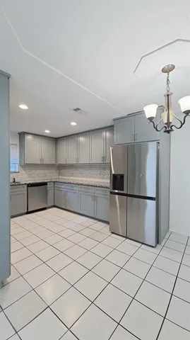 a kitchen with stainless steel appliances kitchen island granite countertop a refrigerator sink and cabinets