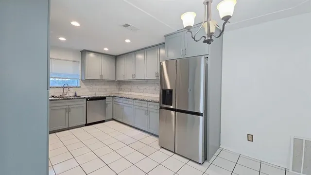 a kitchen with stainless steel appliances a refrigerator sink and microwave