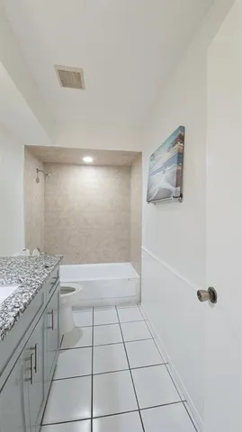 a bathroom with a granite countertop sink a toilet and shower