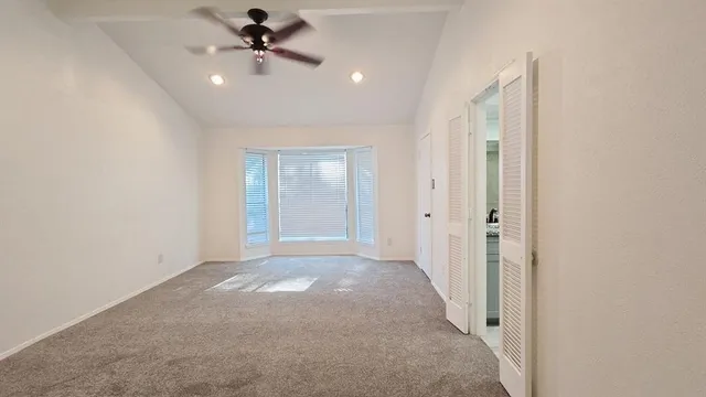 a view of an empty room with a ceiling fan