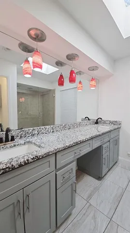 a bathroom with a granite countertop sink and a mirror