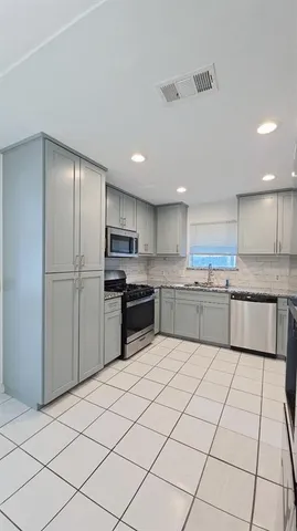 a kitchen with cabinets a sink and white stainless steel appliances