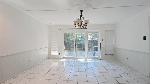 a view of a livingroom with a chandelier fan and windows