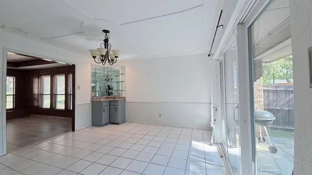 a view of a hallway with windows and chandelier