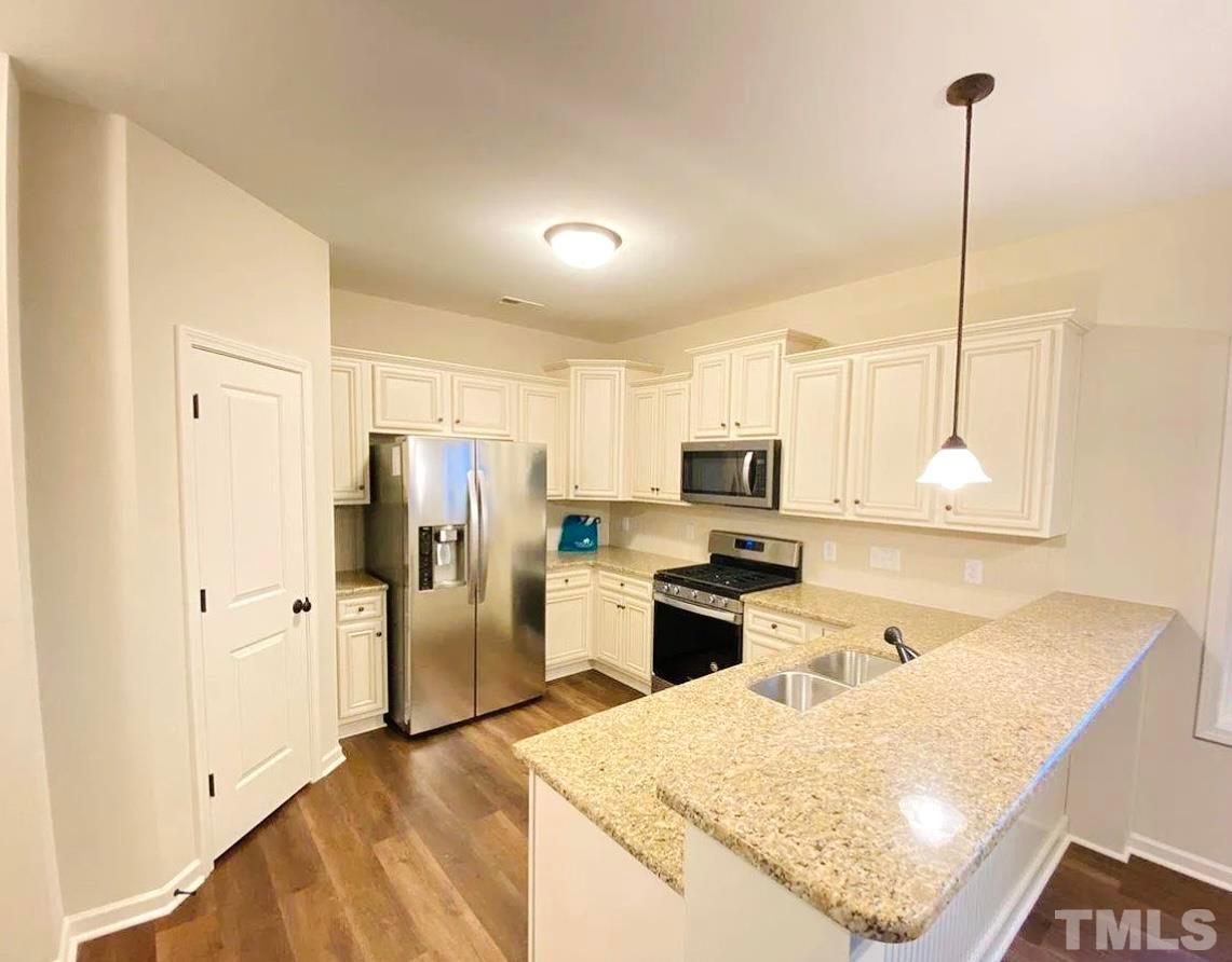 111 Tang Circle Garner, NC 27529 - Photo 2 of 16 a kitchen with stainless steel appliances granite countertop a refrigerator a stove and a sink