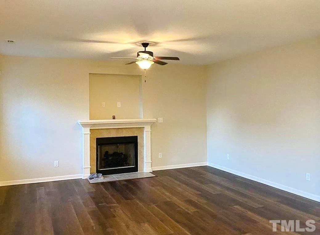 111 Tang Circle Garner, NC 27529 - Photo 3 of 16 a view of an empty room with wooden floor and a fireplace