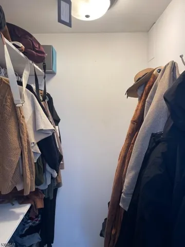 a view of walk in closet with clothes