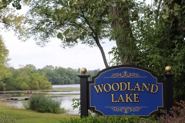 a sign of golf club on a wall under a tree