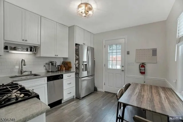a kitchen with a refrigerator and a stove top oven