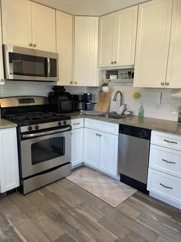 a kitchen with a stove a microwave a sink and cabinets