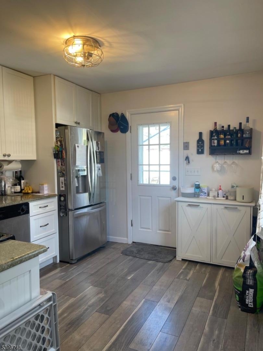 16 Brookside Avenue Pequannock, NJ 07444 - Photo 6 of 30 a kitchen with a sink dishwasher a refrigerator and a stove with wooden floor
