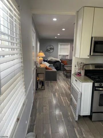 a view of living room kitchen with furniture and wooden floor