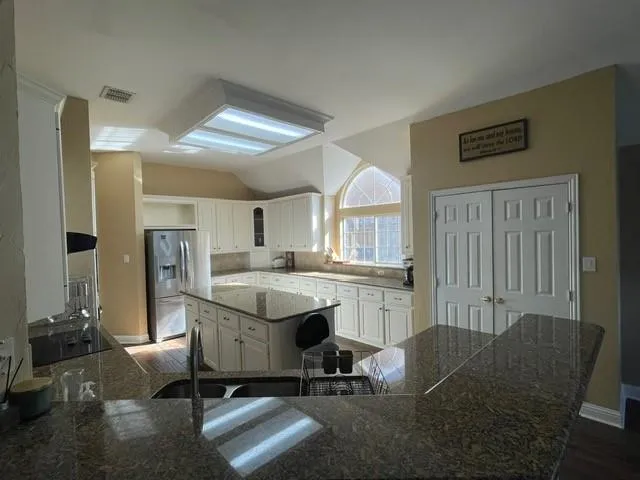 a view of a workspace with furniture and a window