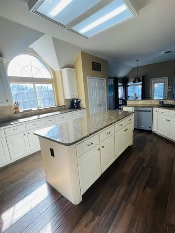 a kitchen with stainless steel appliances granite countertop a sink a stove and a wooden floors