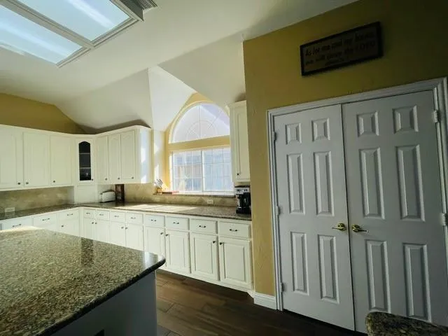 a kitchen with granite countertop a sink and cabinets
