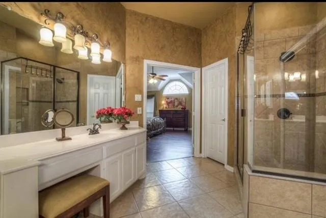 a en suite bathroom with a sink a mirror and shower