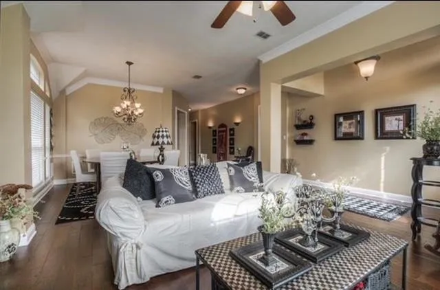 a living room with furniture a dining table and a chandelier