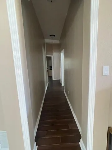 a view of a hallway with wooden floor