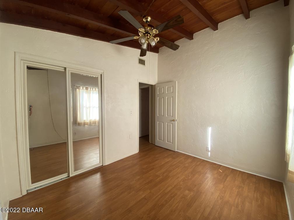 114 Essex Drive Ormond Beach, FL 32176 - Photo 18 of 21 en empty room with wooden floor and ceiling fan