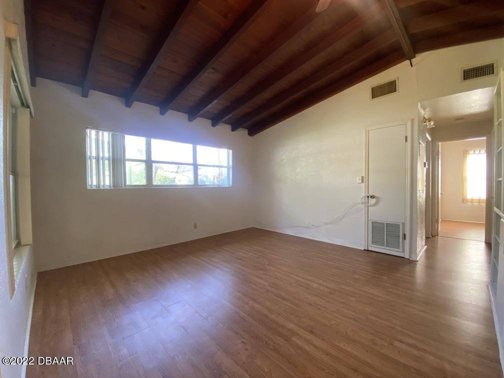 114 Essex Drive Ormond Beach, FL 32176 - Photo 9 of 21 a view of an empty room with wooden floor and a window