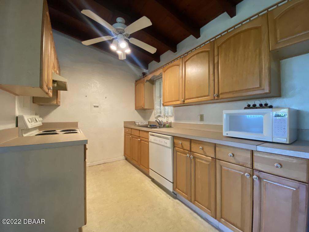 114 Essex Drive Ormond Beach, FL 32176 - Photo 10 of 21 a kitchen with sink cabinets and window