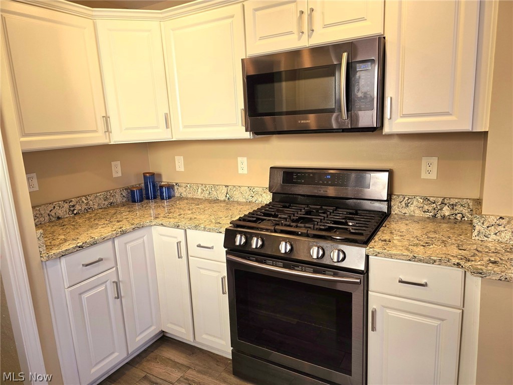 4111 Redfern Road Parma, OH 44134 - Photo 3 of 40 Kitchen with granite countertops, white cabinetry, stainless steel gas range and microwave