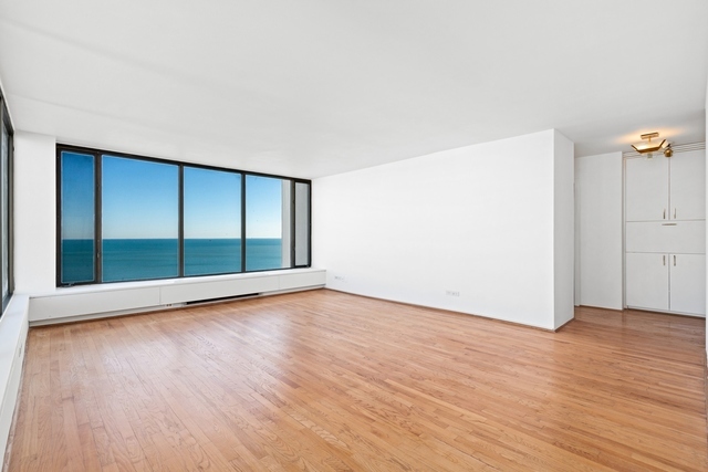 5455 North Sheridan Road, Unit 2301 Chicago, IL 60640 - Photo 4 of 18 an empty room with wooden floor and windows