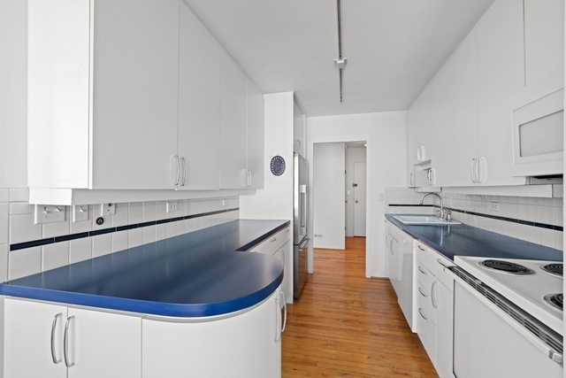 5455 North Sheridan Road, Unit 2301 Chicago, IL 60640 - Photo 6 of 18 a kitchen with kitchen island granite countertop a sink a stove and refrigerator